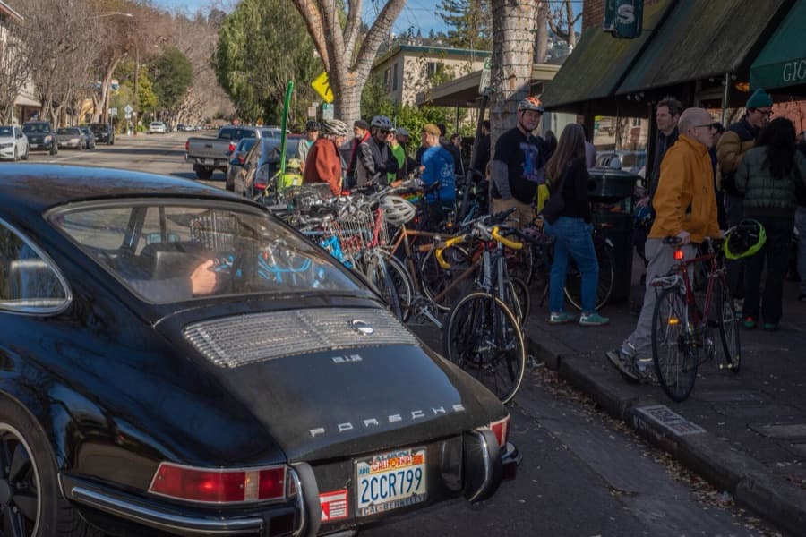 Cyclists and pedestrians gathered on Hopkins Street next to parked cars